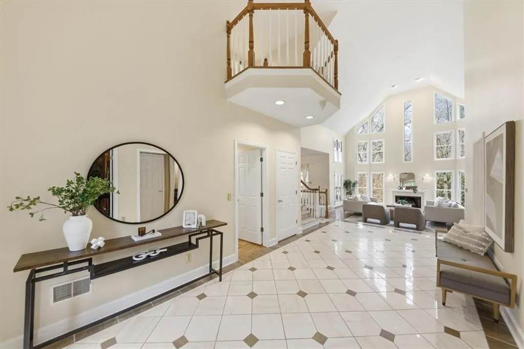Entryway with a high ceiling, light tile patterned floors, a fireplace, stairway, and recessed lighting