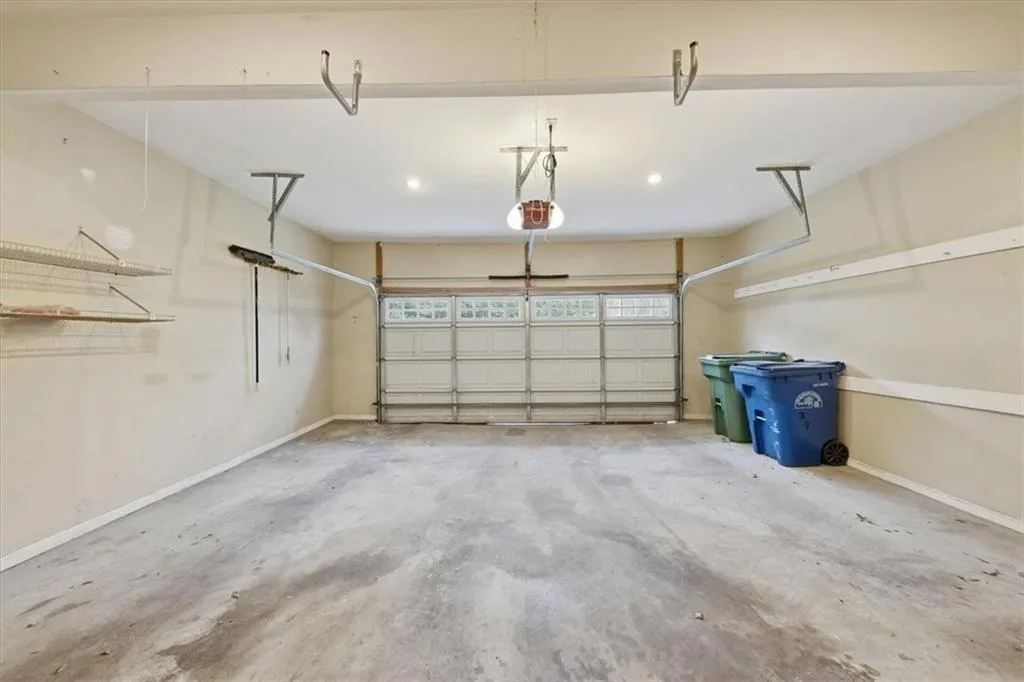 Garage with baseboards and a garage door opener
