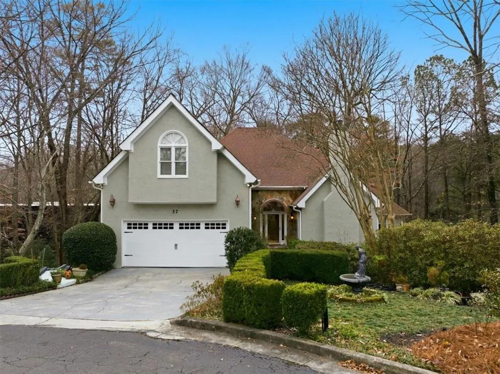 Traditional home with concrete driveway, stucco siding, stone siding, and an attached garage