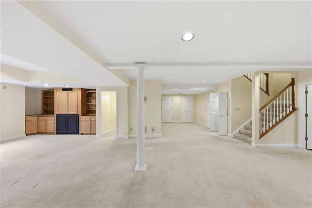 Finished basement featuring stairway, recessed lighting, and light carpet