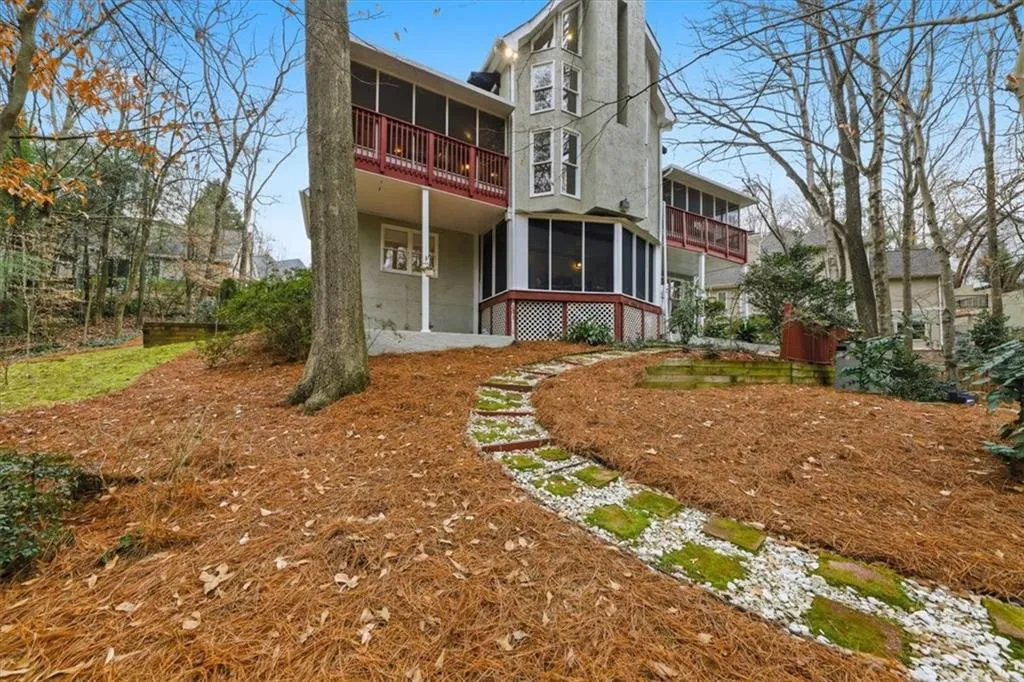 Back of property featuring a balcony, a sunroom, and stucco siding