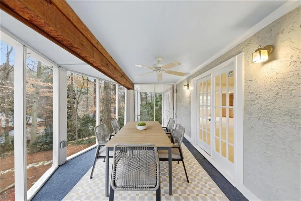 Sunroom / solarium with outdoor dining space, ceiling fan, french doors, and beamed ceiling