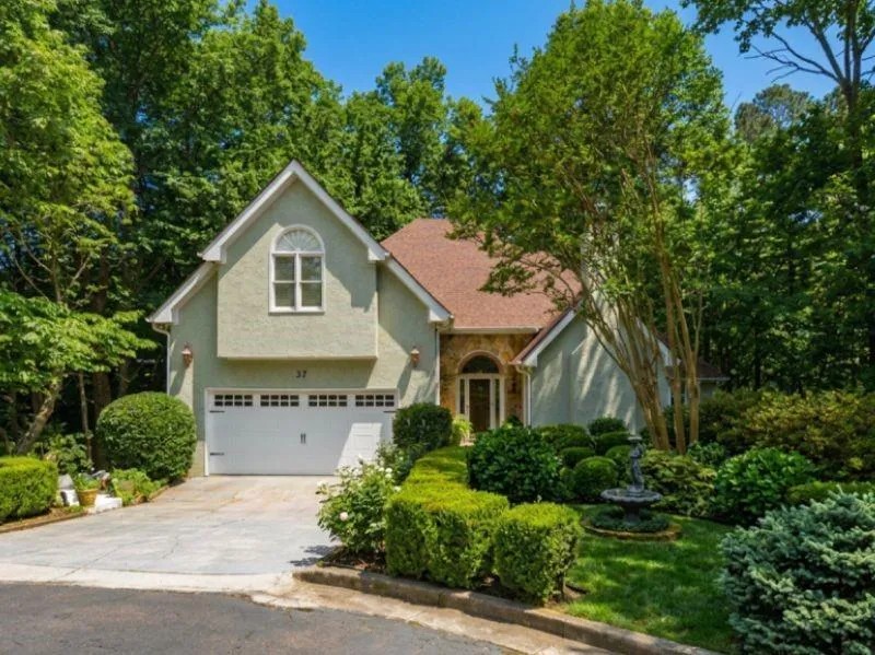 Stucco exterior with a terracotta-style roof and an integrated two-car garage