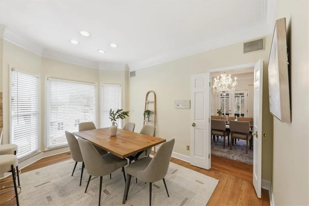 Dining space featuring ornamental molding, light wood finished floors, a chandelier, and recessed lighting