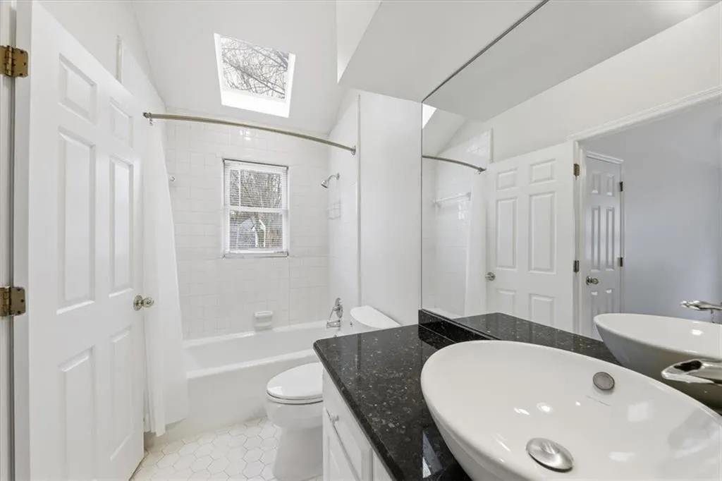 Bathroom featuring shower / bath combo, vanity, and light tile patterned flooring