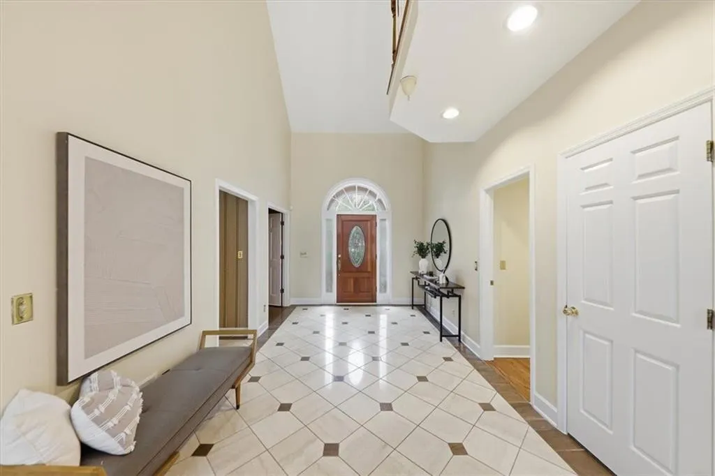 Tiled entryway featuring a towering ceiling and recessed lighting