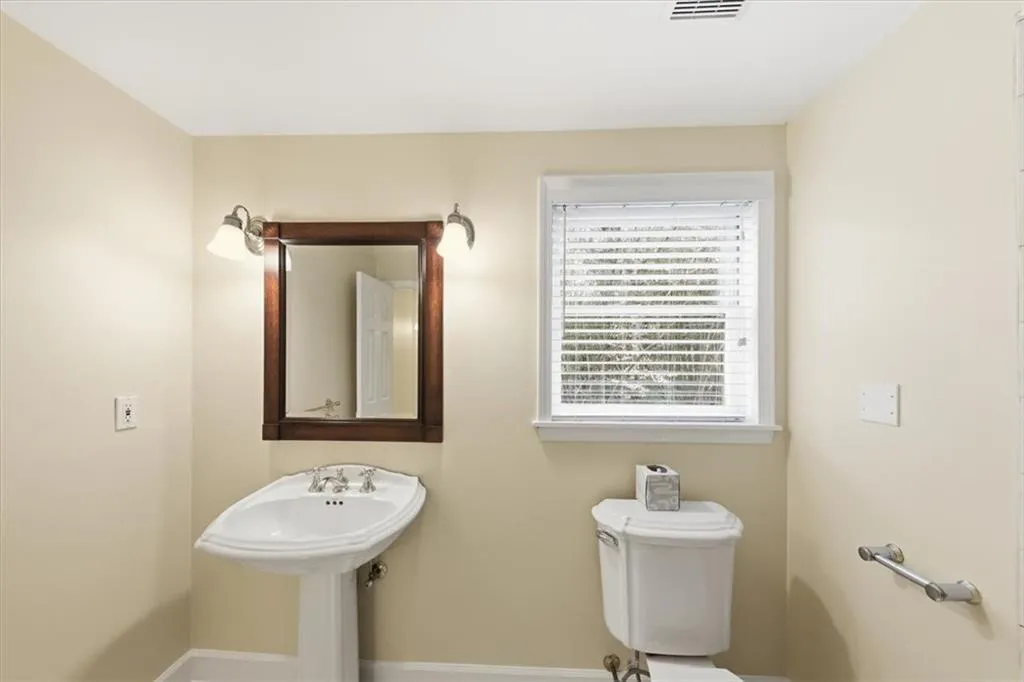 Half bathroom with toilet and baseboards