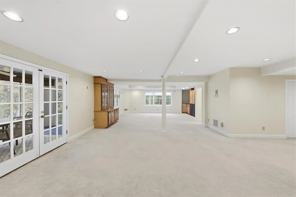 Unfurnished living room with french doors, light carpet, and recessed lighting