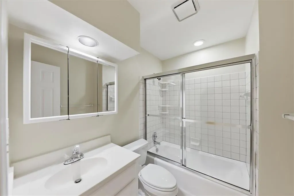 Full bathroom featuring bath / shower combo with glass door and vanity