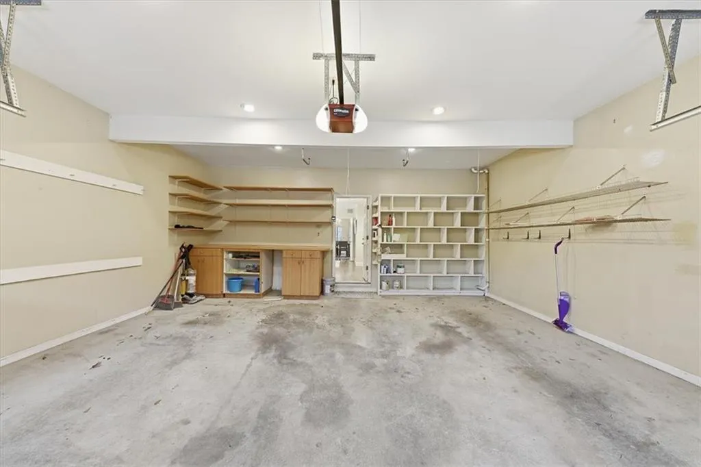 Garage featuring baseboards and a garage door opener