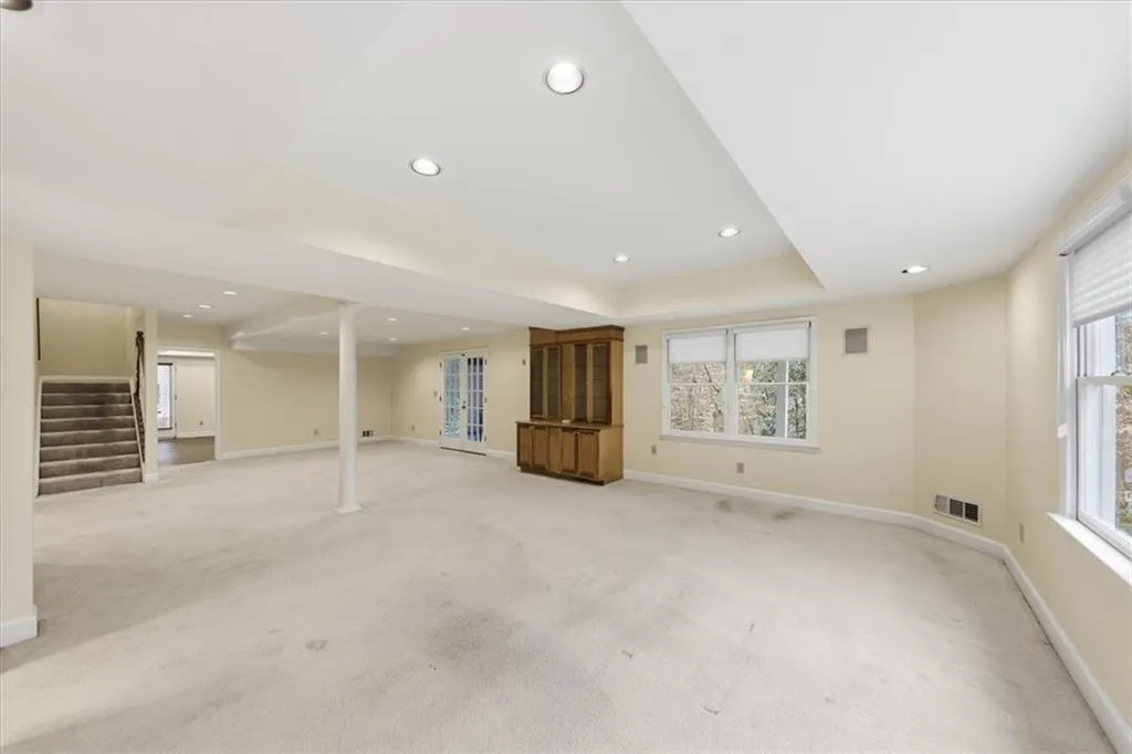 Basement featuring stairs, light carpet, recessed lighting, and plenty of natural light