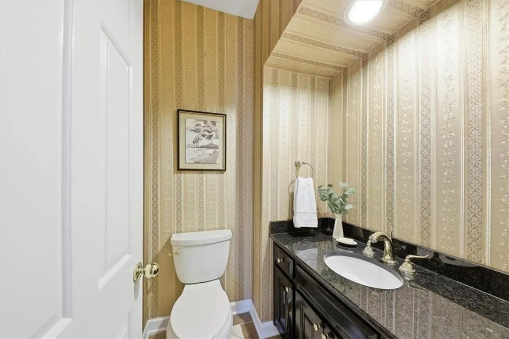 Bathroom with vanity and wallpapered walls