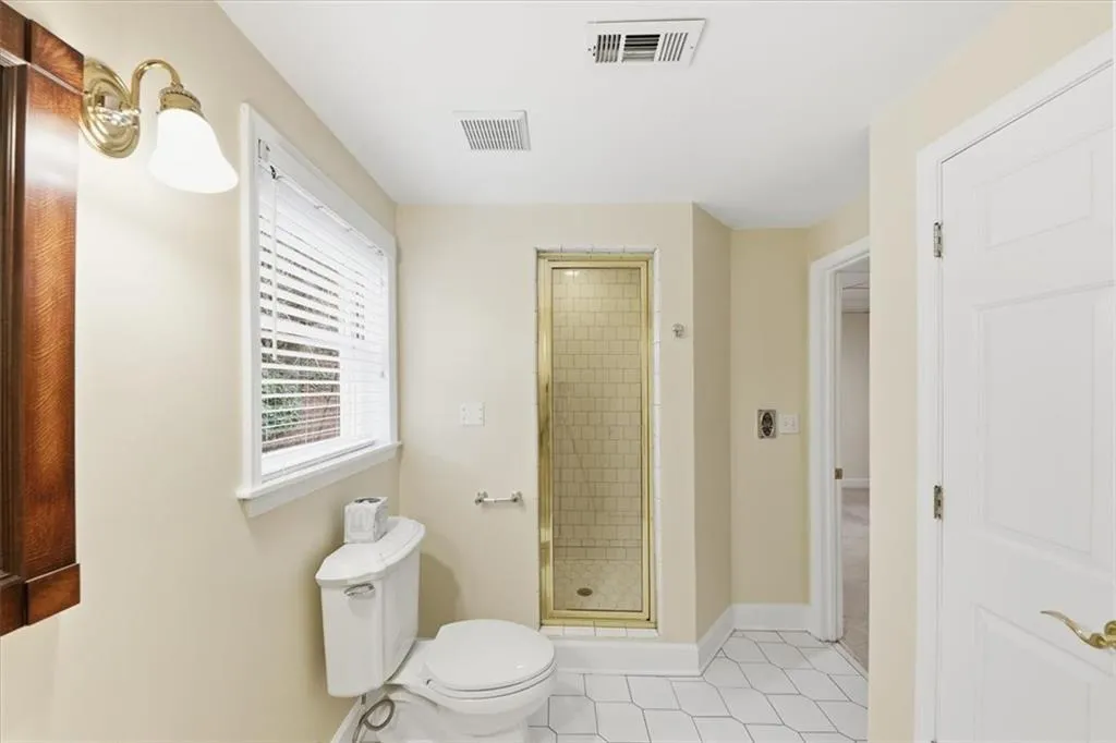 Bathroom with a stall shower and light tile patterned floors