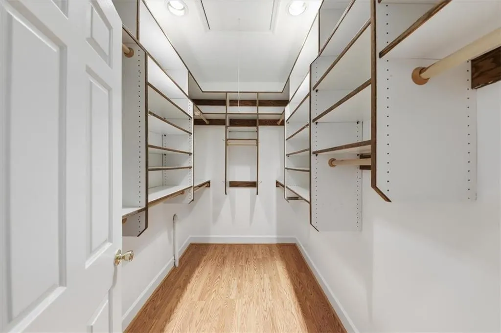 Spacious closet with light wood-type flooring and attic access