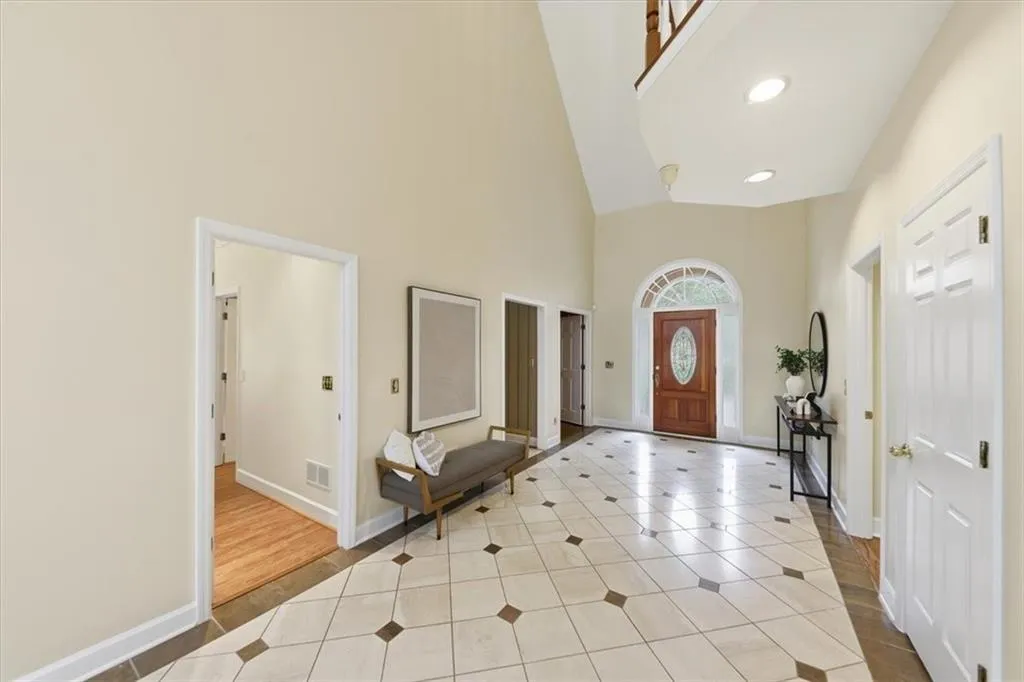 Tiled entryway featuring a towering ceiling and recessed lighting