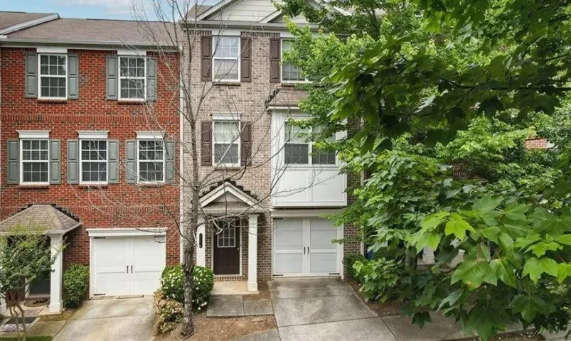 Multi-story townhouse with a brick facade and shuttered windows
