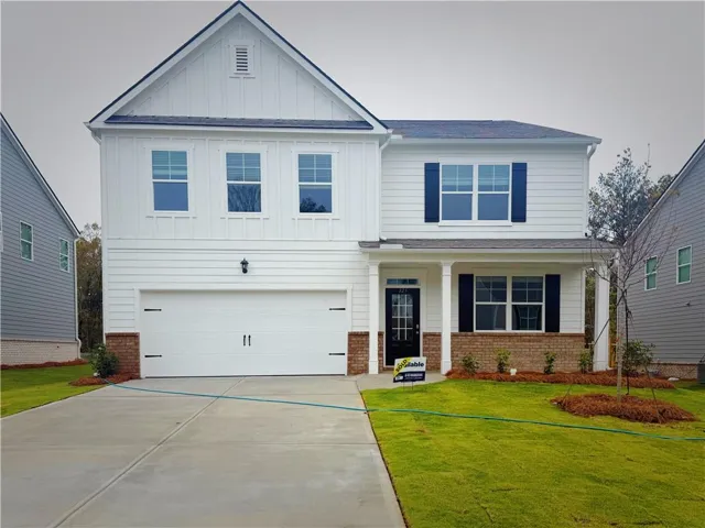 Two-story home with white vertical and horizontal siding, a two-car garage, and a covered front porch supported by columns