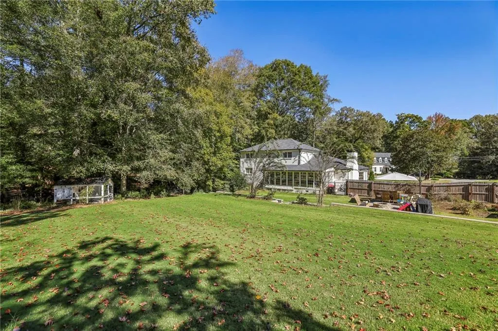 View of green lawn featuring view of wooded area