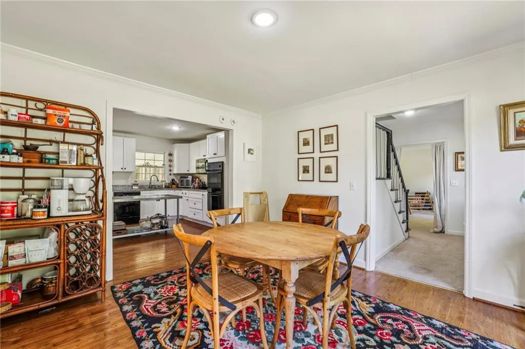 Dining room featuring crown molding, dark wood-type flooring, and stairway