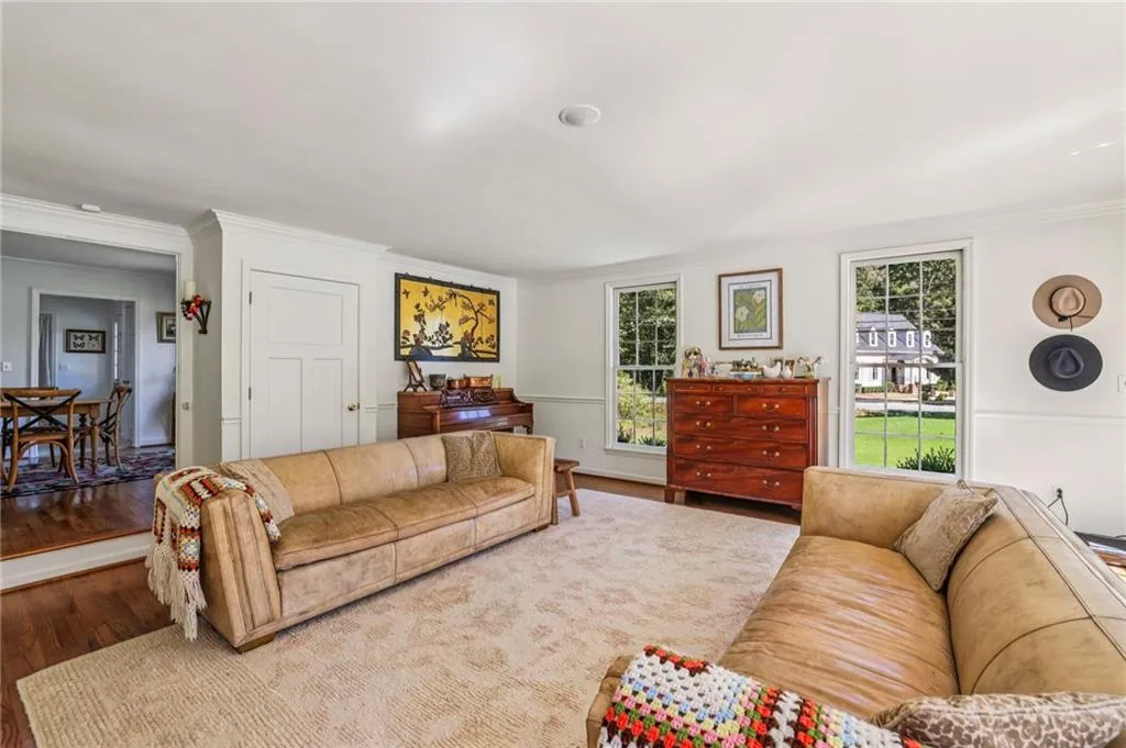 Living area with wood finished floors and crown molding