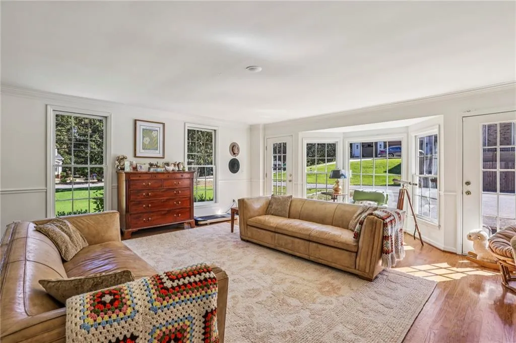 Living area featuring wood finished floors, plenty of natural light, and crown molding