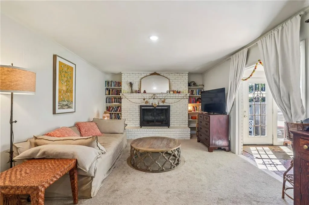 Carpeted living room with a fireplace, ornamental molding, and recessed lighting