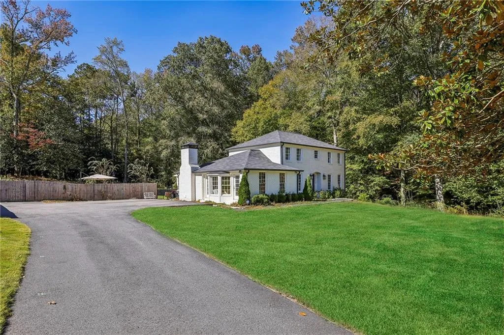 View of front of home with a chimney and driveway