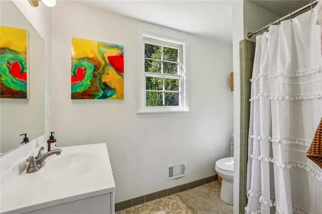 Full bathroom featuring vanity, curtained shower, and tile patterned floors