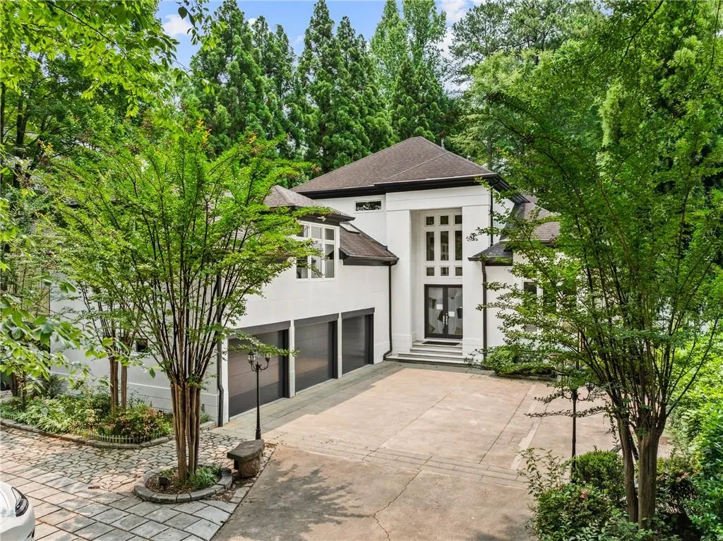 View of outdoor structure featuring concrete driveway, a garage, and view of wooded area