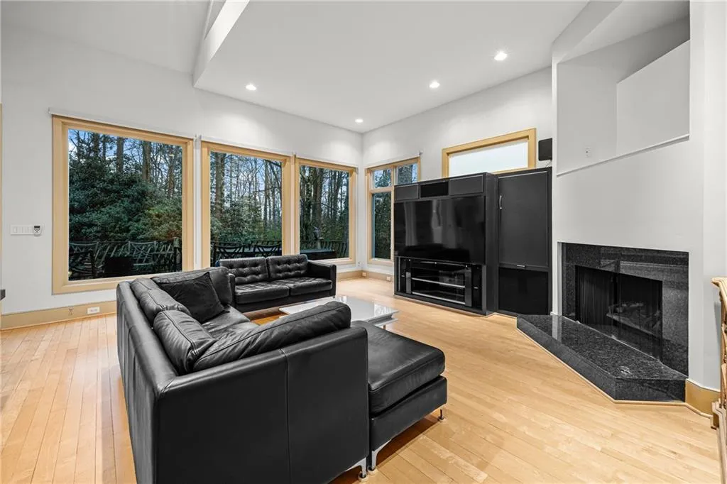 Living room with recessed lighting, a premium fireplace, and light wood-style floors