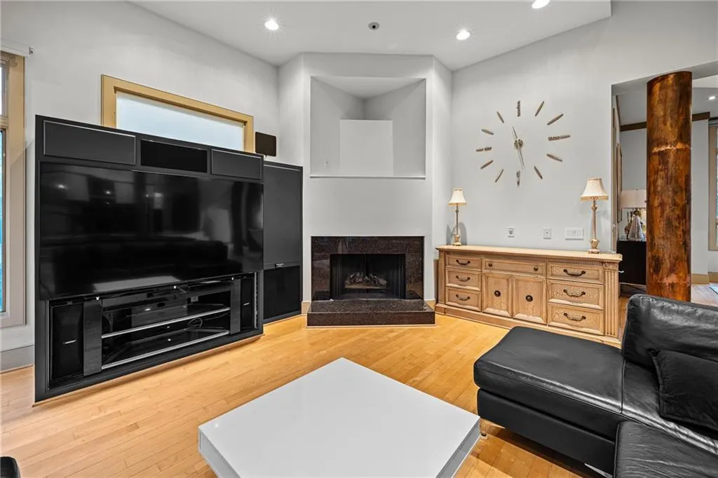 Living area featuring a fireplace, light wood-style flooring, and recessed lighting