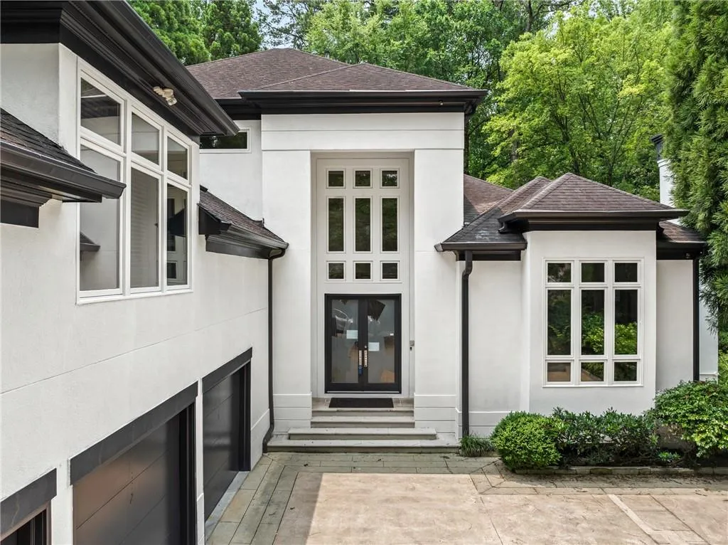 Property entrance with stucco siding and a shingled roof