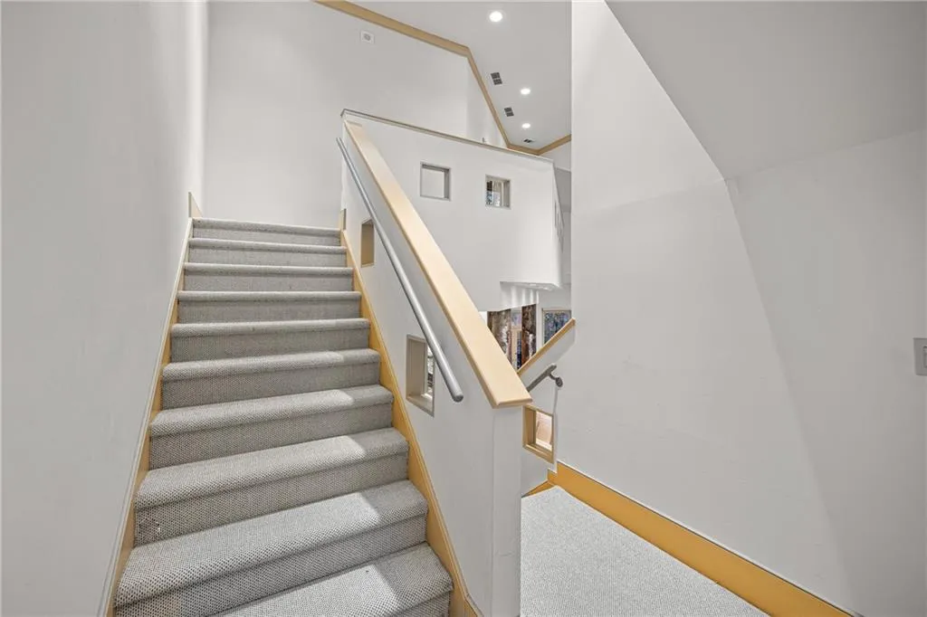 Stairway with carpet floors and recessed lighting