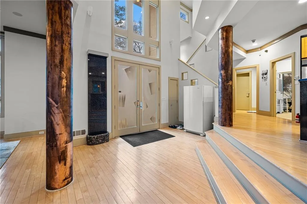 Foyer entrance with light wood finished floors, a high ceiling, and recessed lighting