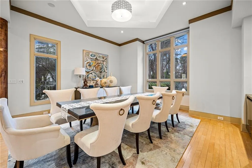Dining area featuring light wood finished floors, crown molding, a tray ceiling, and recessed lighting