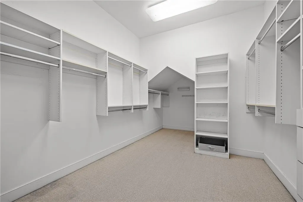 Spacious closet with light colored carpet