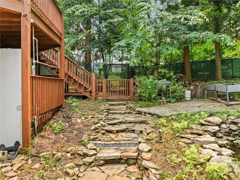 Fenced backyard with stairs and a wooden deck