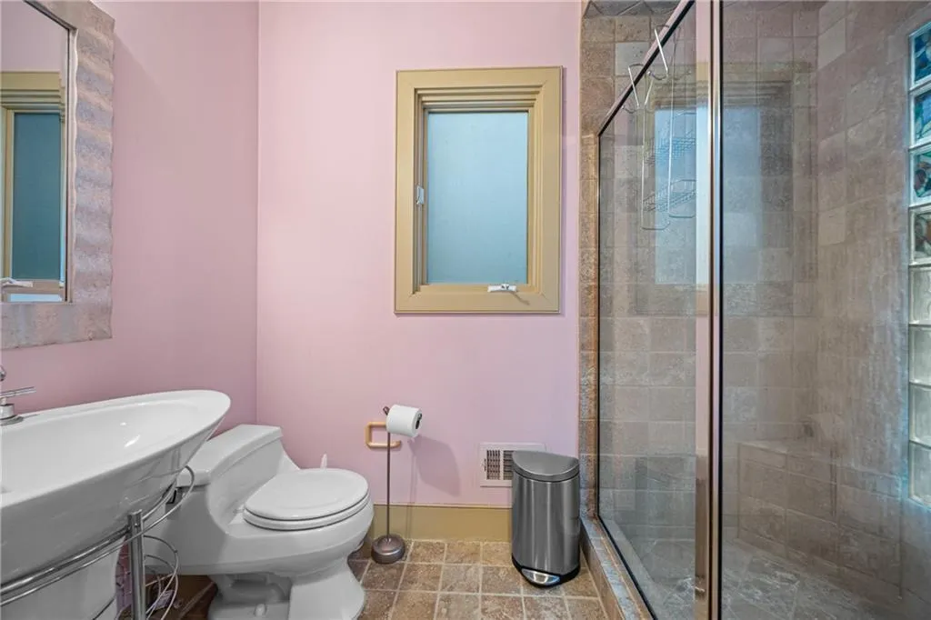Bathroom with a shower stall and tile patterned flooring