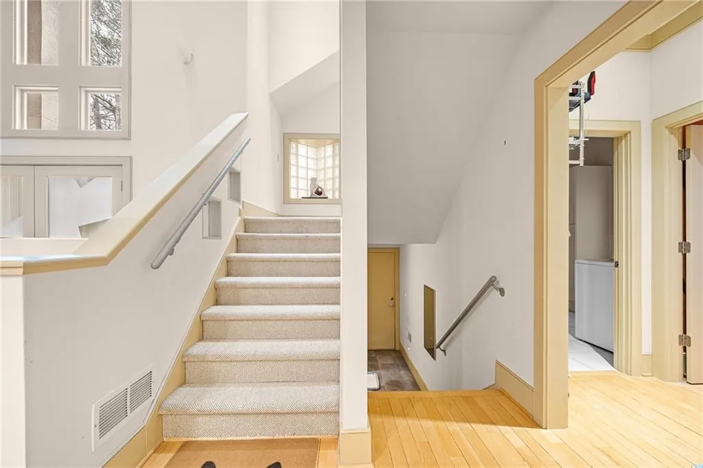 Staircase with a high ceiling and wood finished floors