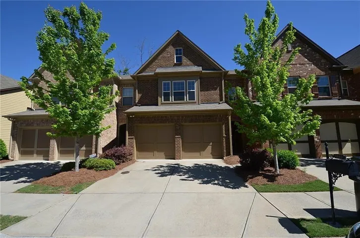 Brick exterior with gabled roofline, multiple windows, and a two-car garage