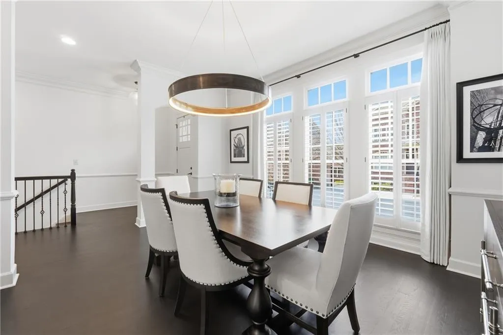 Dining area with ornamental molding and dark wood-style floors