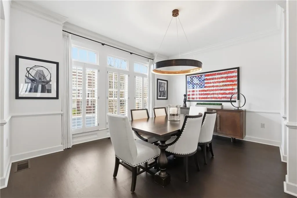 Dining space with ornamental molding and dark wood-style flooring