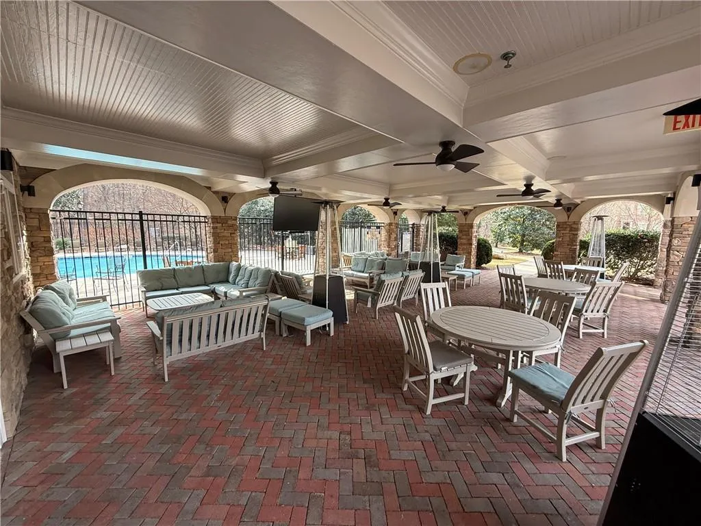 View of patio with outdoor lounge area, a ceiling fan, outdoor dining space, and a community pool