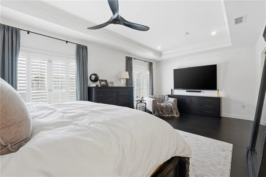 Bedroom with ceiling fan, recessed lighting, dark wood-type flooring, crown molding, and a raised ceiling