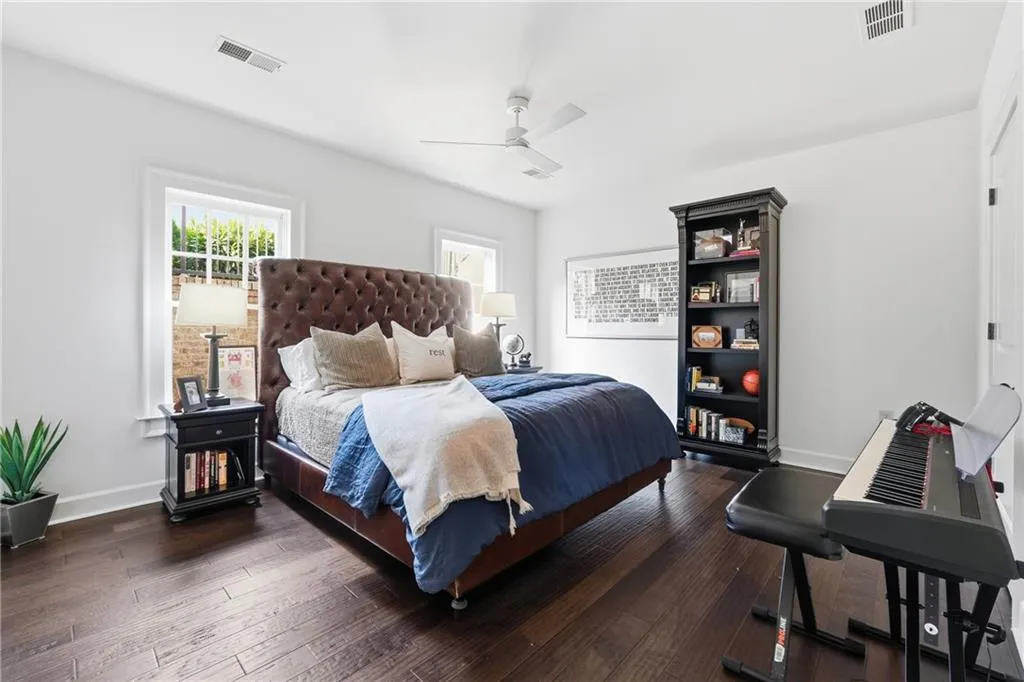 Bedroom featuring dark wood-type flooring and a ceiling fan