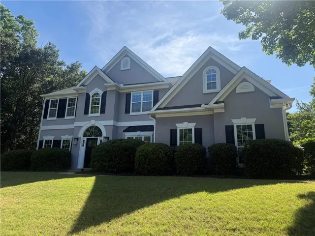 Two-story stucco exterior with multiple gables and dormer windows