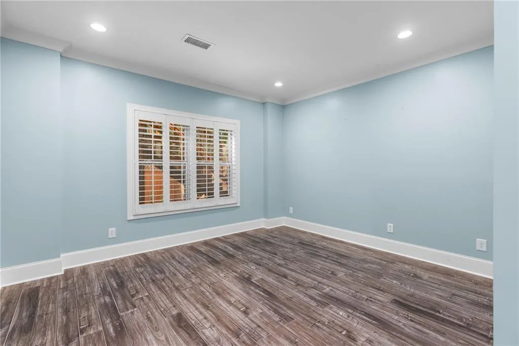 Spare room with dark hardwood / wood-style flooring and crown molding