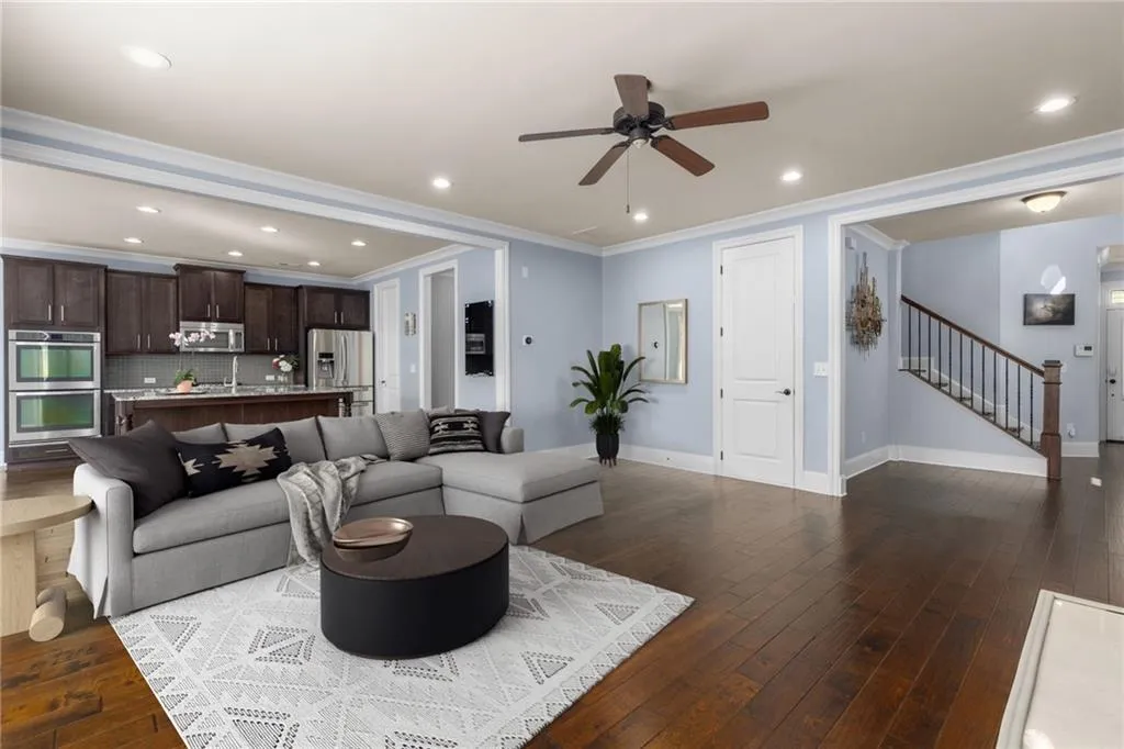 Living room with hardwood / wood-style floors, ornamental molding, and ceiling fan