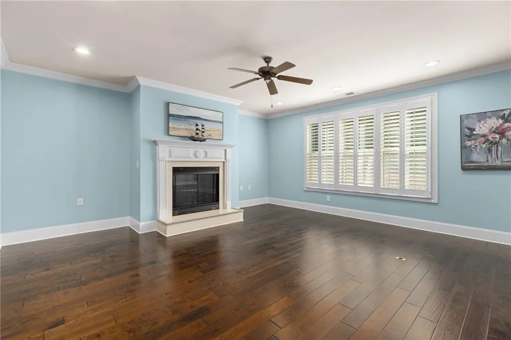 Unfurnished living room with ornamental molding, ceiling fan, and dark hardwood / wood-style floors