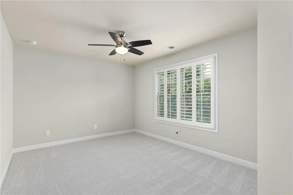 Carpeted empty room with ceiling fan
